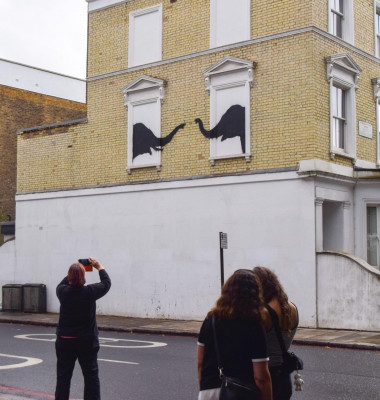 People take photos of a new artwork, confirmed to be by Banksy, on a wall of a house in Chelsea. The artwork, depicting a pair of elephants, is the second new artwork in London in two days by the elusive street artist.