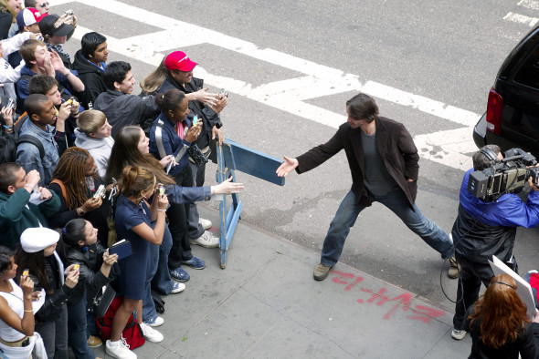 keanu reeves pe strada intinde mana catre un grup de fani