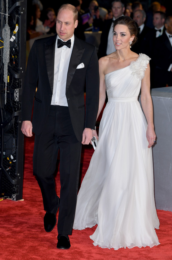 Printul William in frac si Kate Middleton in rochie alba pasesc pe covorul rosu de la Bafta 2019