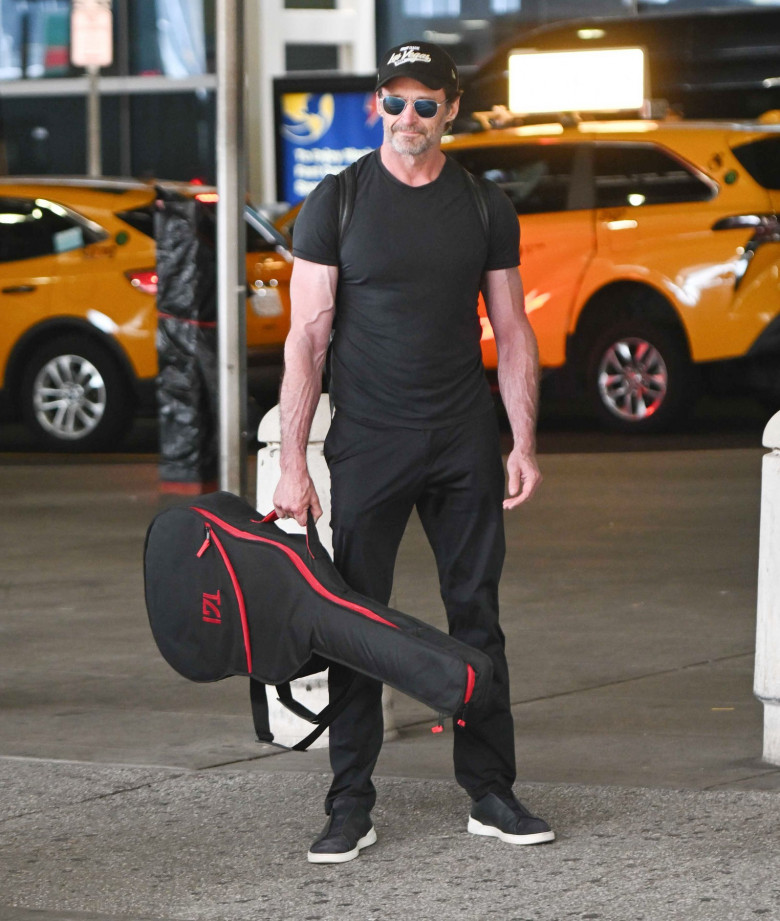 EXCLUSIVE: Hugh Jackman Shows Off His Muscles While Arriving to JFK Airport in New York City.