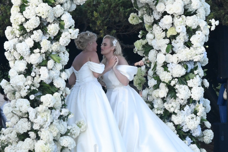 *PREMIUM-EXCLUSIVE* *MUST CALL FOR PRICING * Australian actress Rebel Wilson and her fashion designer fiancée Ramona Agruma look stunning in white wedding dresses as the couple are married in a beautiful ceremony at the Hotel Cala di Volpe in Sardinia