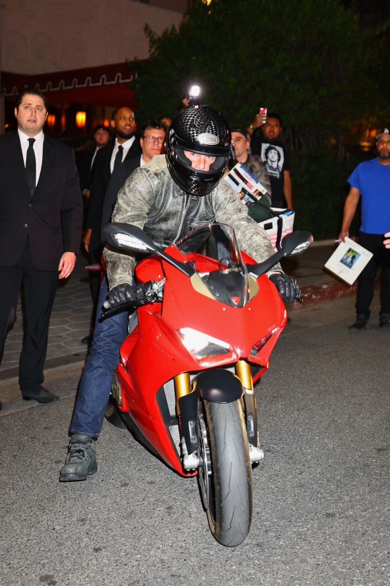 Tom Cruise rides out of a party at Sunset on a red Ducati