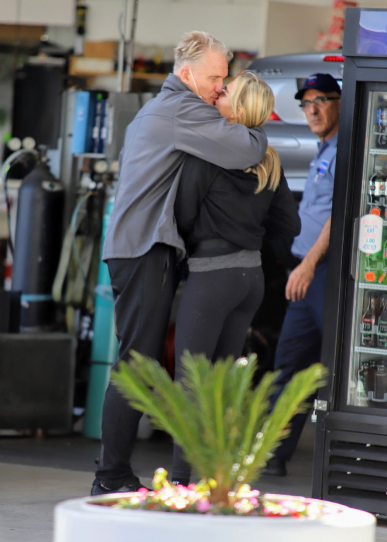 EXCLUSIVE: Dolph Lundgren 62 and his 40 years younger fiance Emma Krokdal pull in for a quick tune up and some PDA while wearing a shirt that mentions him and Rocky cast