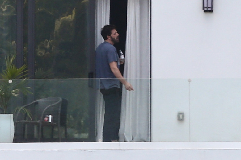 Ben Affleck takes a smoke break on his hotel balcony while out staying in Miami