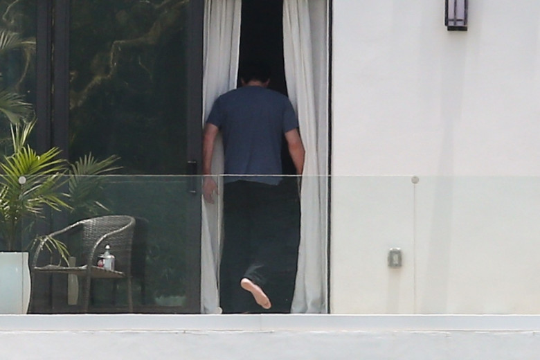 Ben Affleck takes a smoke break on his hotel balcony while out staying in Miami