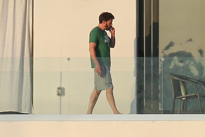 Ben Affleck looks right at home as he steps out on the balcony to smoke a cigarette wearing a Green Monstah while enjoying his Miami getaway with Jennifer Lopez