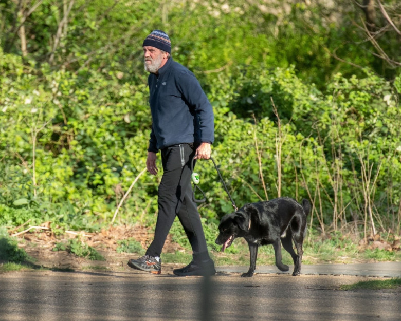 *EXCLUSIVE* *WEB MUST CALL FOR PRICING* Hugh Laurie looks unrecognisable in a tracksuit, a beanie hat and trainers and a full bushy beard as he was spotted taking his dog for a walk in London.