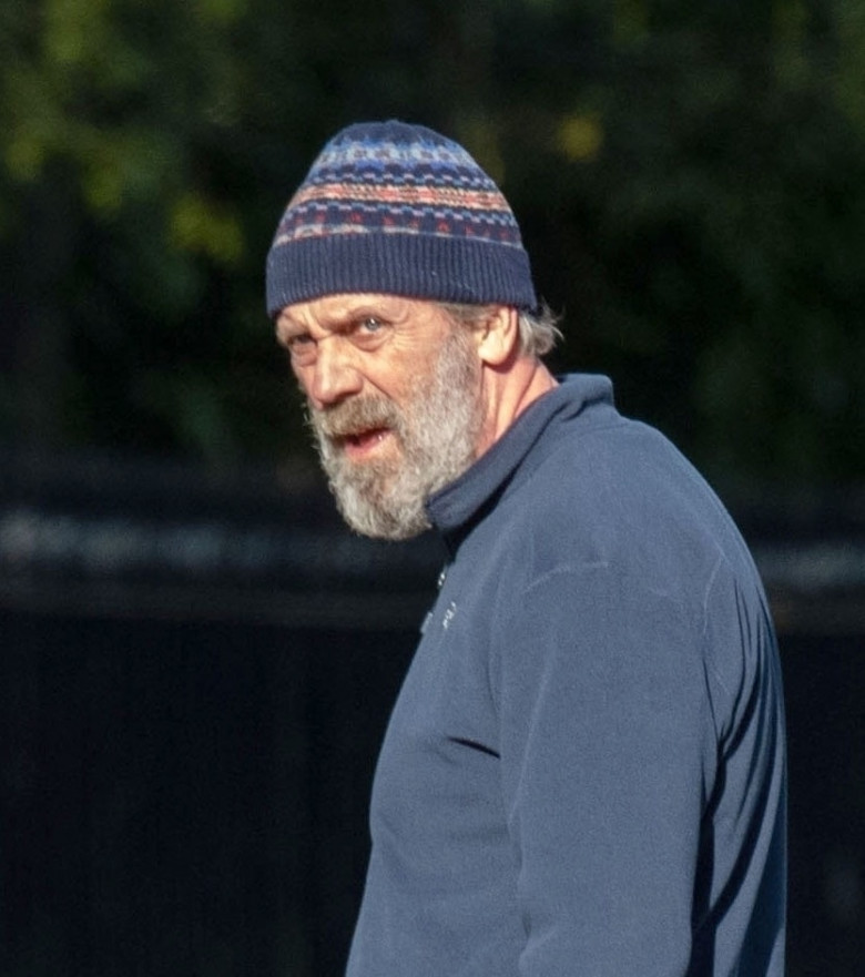 *EXCLUSIVE* *WEB MUST CALL FOR PRICING* Hugh Laurie looks unrecognisable in a tracksuit, a beanie hat and trainers and a full bushy beard as he was spotted taking his dog for a walk in London.