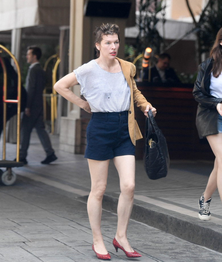 EXCLUSIVE: Mila Jovovich shows of an interesting new hairstyle as she arrives at the Four Seasons