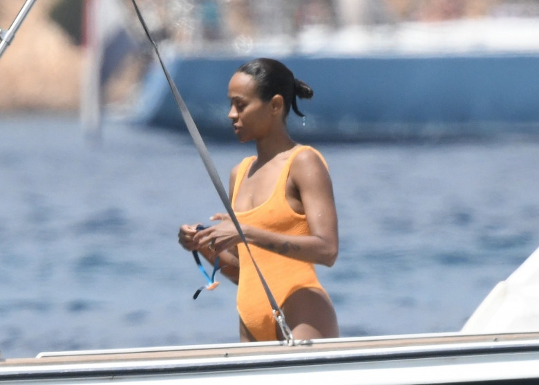 *EXCLUSIVE* Showing off her sexy little figure wearing her striking orange swimsuit, Zoe Saldana and husband Marco Perego enjoy a swim at Pevero beach during their family holiday in Sardinia.