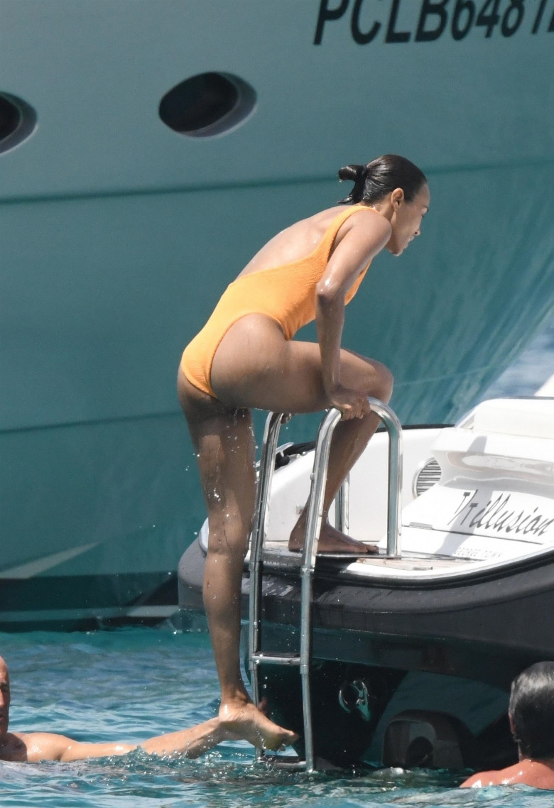 *EXCLUSIVE* Showing off her sexy little figure wearing her striking orange swimsuit, Zoe Saldana and husband Marco Perego enjoy a swim at Pevero beach during their family holiday in Sardinia.