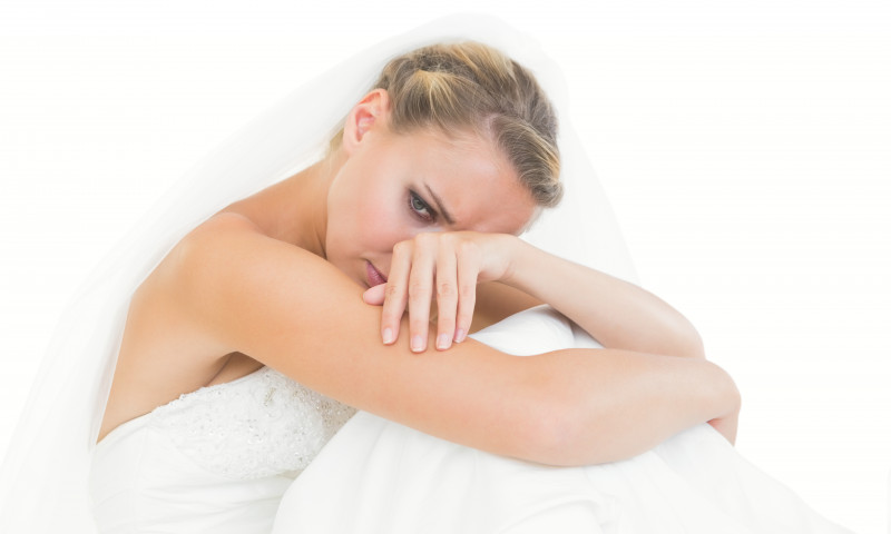 Upset,Young,Bride,Sitting,On,Floor,On,White,Background