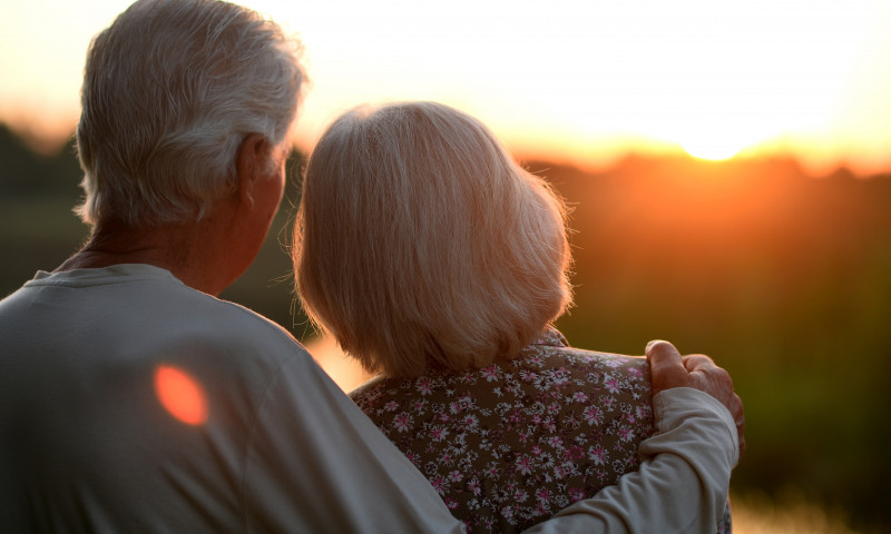 Elderly,Couple,Hugs,And,Looks,At,The,Sunset.,Rear,View