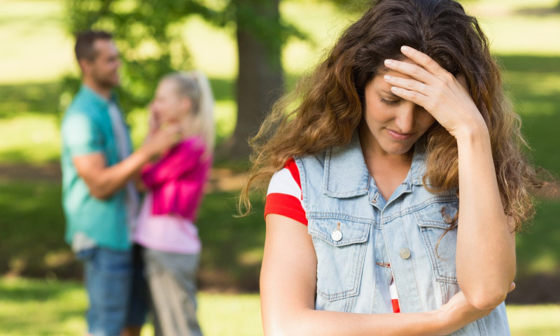 Angry woman with man and girlfriend in background at park