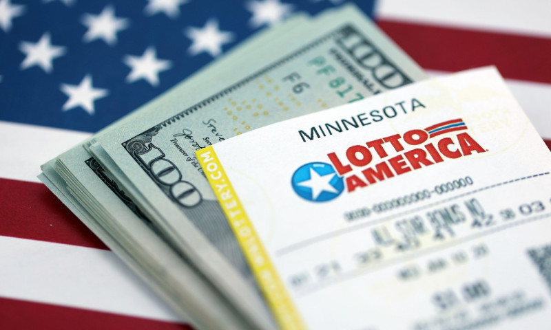 KYIV, UKRAINE - OCTOBER 22, 2025 Lotto America lottery ticket lies on dollar bills and US flag close up