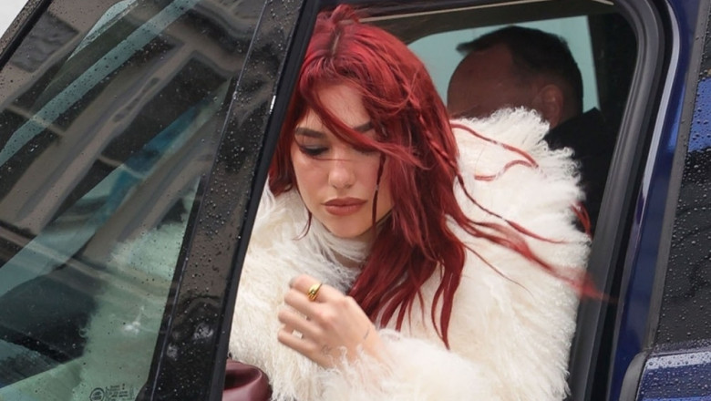 Dua Lipa looks chic wearing a fluffy coat and burgundy boots to match her hair at the Capital Radio Studios in London.