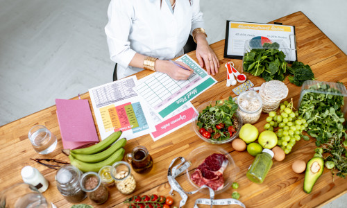 Writing a diet plan on the table full of healthy food