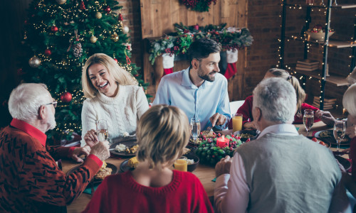 Photo of full family gathering sitting dinner table communicating chatting overjoyed x-mas party multi-generation in newyear decorated living room indoors