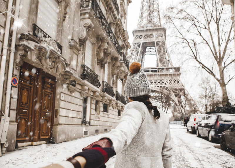 Poza cu un cuplu in Paris pe ninsoare in fata turnului Eiffel