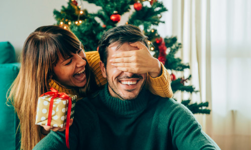 Romantic young couple exchanging Christmas gifts