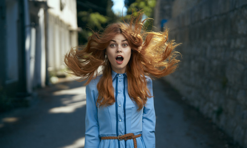 Wind blowing hair of surprised Caucasian woman