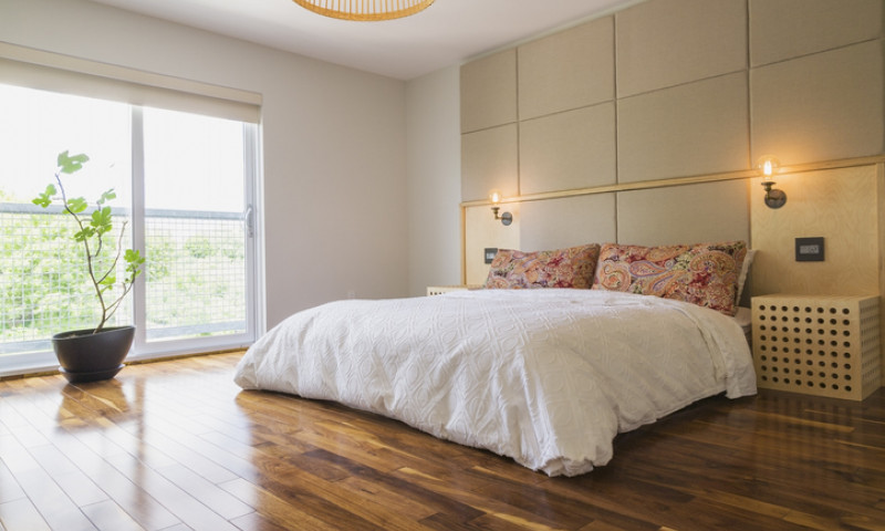 King size bed in bedroom with American walnut hardwood flooring on the upstairs floor inside a modern cube style home, Quebec, Canada