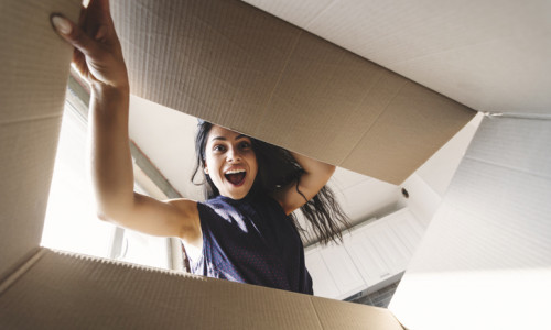 Smiling woman opening a carton box