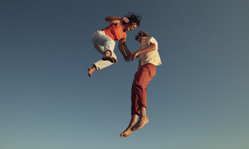 Cheerful friends jumping high up in mid-air