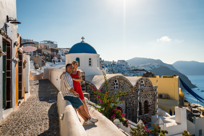 Young adult couple sitting in Santorini, Greece