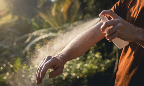 Man while applying insect repellent