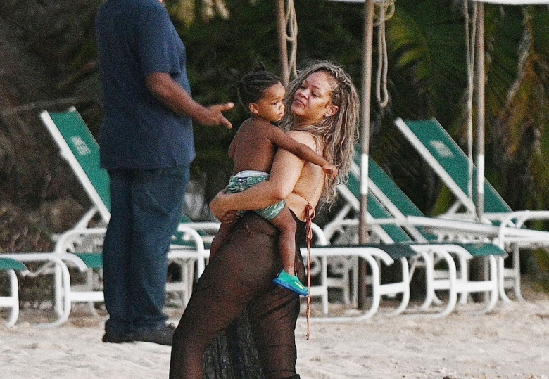 *PREMIUM-EXCLUSIVE* *MUST CALL FOR PRICING* The Grammy-Winning Superstar Rihanna wears her sultry black maxi beach dress watching the sun go down and taking a dip in the sea with her beau Asap Rocky during their family holiday in Barbados.**PICTURES TAKE