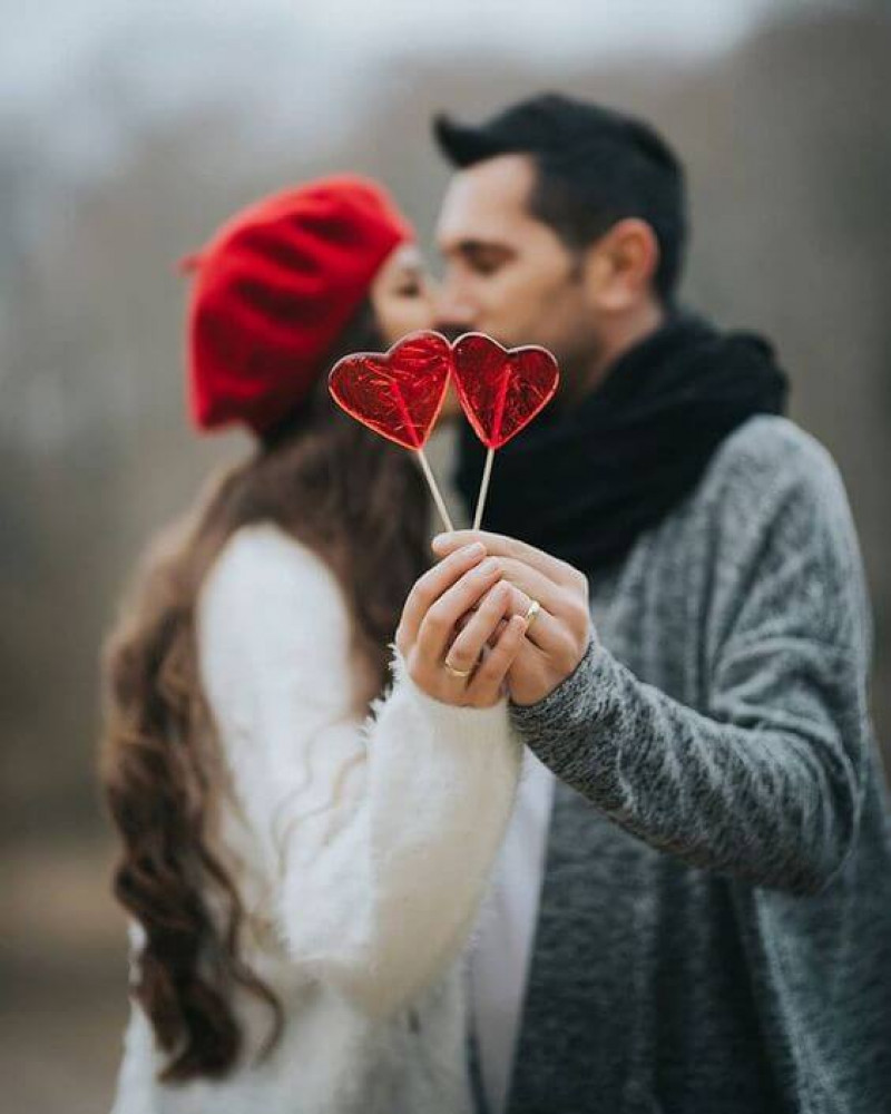 a lovely Valentine's Day engagement pic with red heart popsicles is a very cute and cool idea