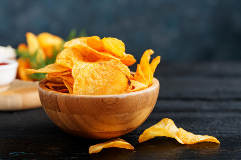 Crispy,Potato,Chips,In,Bowl,On,Dark,Wooden,Background.