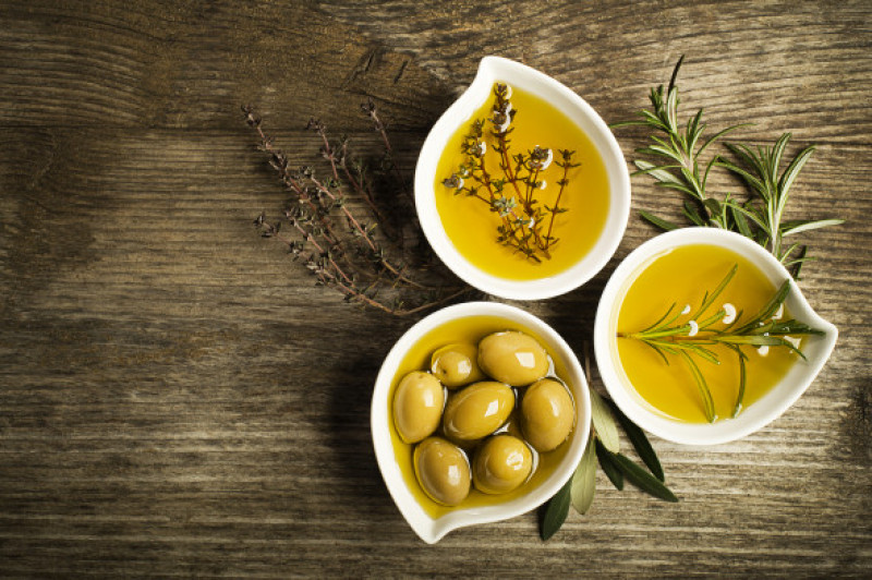 Olive,Oil,With,Fresh,Herbs,On,Wooden,Background.