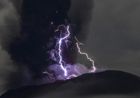 Imagini cu erupţia vulcanului Ibu din Indonezia, pe fundalul fulgerelor