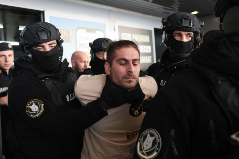 Cosmin Costinel Zuleam este escortat de către polițiști în afara aeroportului internațional Henri Coandă din Otopeni, 21 ianuarie 2026. Inquam Photos George Călin (2)