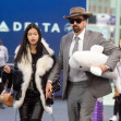 *EXCLUSIVE* Nicolas Cage holds hands with girlfriend Riko Shibata carrying a beluga whale plush toy upon arrival at JFK