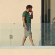 Ben Affleck looks right at home as he steps out on the balcony to smoke a cigarette wearing a Green Monstah while enjoying his Miami getaway with Jennifer Lopez