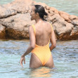 *EXCLUSIVE* Showing off her sexy little figure wearing her striking orange swimsuit, Zoe Saldana and husband Marco Perego enjoy a swim at Pevero beach during their family holiday in Sardinia.