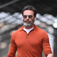 Hugh Jackman wears an orange pullover shirt and brown suede shoes in New York City