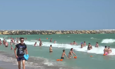 Turist scos cu forța din apă și încătușat de jandarmi, în stațiunea Venus. Pe litoral sunt valuri mari și e arborat steagul roșu