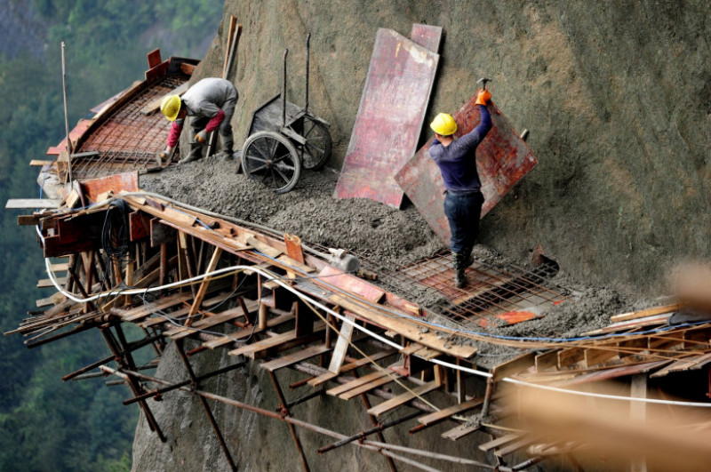 workers making a path on a rock
