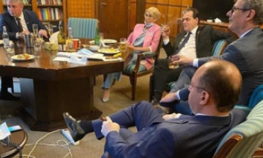Fotografie cu premierul și mai mulți miniștri fumând și aparent consumând alcool într-un birou, publicată de Eugen Teodorovici