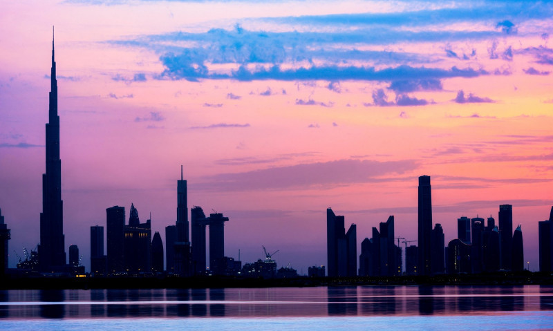 Stunning view of the silhouette of the Dubai skyline during a beautiful sunset. Amazing colored sky with shades of orange, pink and magenta. Dubai.