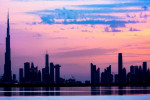 Stunning view of the silhouette of the Dubai skyline during a beautiful sunset. Amazing colored sky with shades of orange, pink and magenta. Dubai.