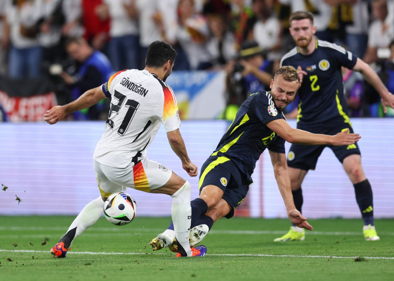 Munich, Germany, 14th June 2024. Ryan Porteous of Scotland tackles Ilkay Gundogan of Germany on the ankle with his studs
