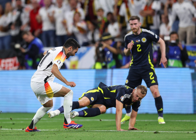 Munich, Germany, 14th June 2024. Ryan Porteous of Scotland tackles Ilkay Gundogan of Germany on the ankle with his studs