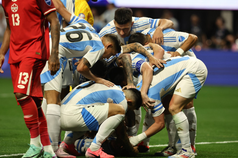Argentina s midfielder Alexis Mac Allister (hidden-bottom-C) is helped by teammates during the Copa America USA 2024, gr