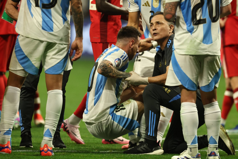 Argentina s forward Lionel Messi (C) is helped by assistant during the Copa America USA 2024, group A, groupe stage matc