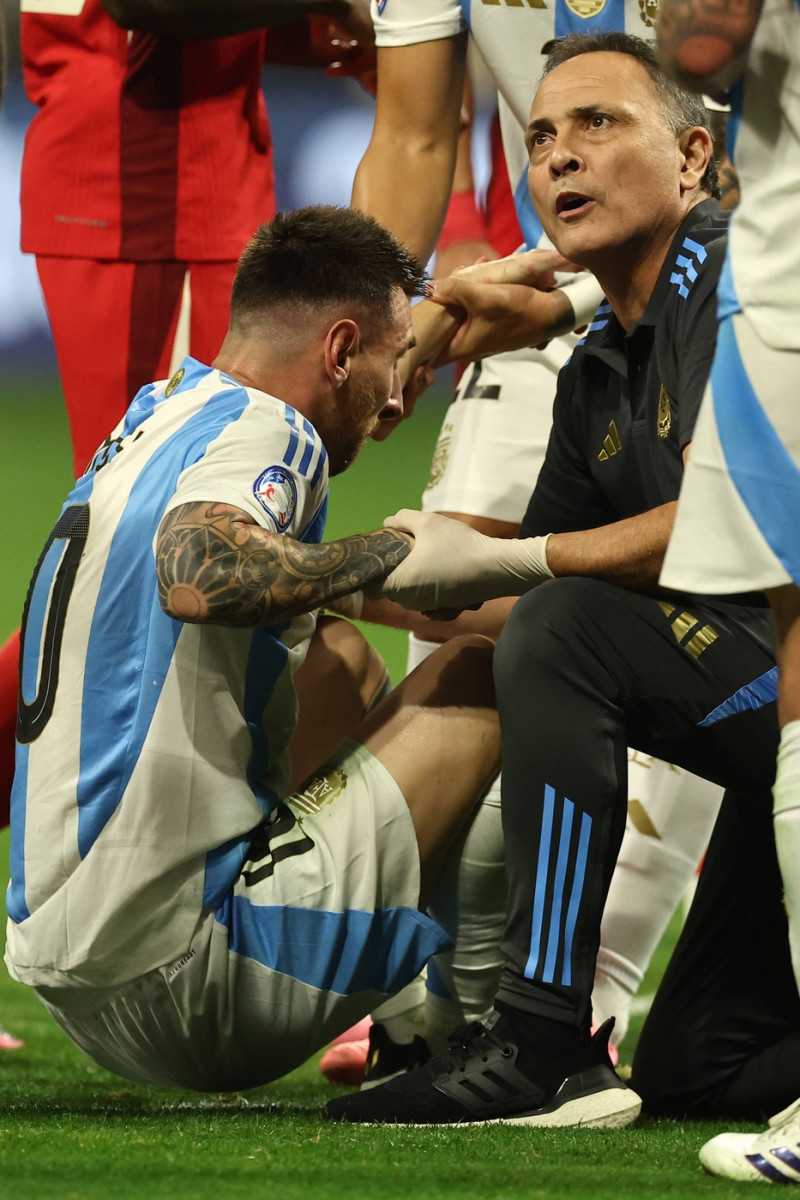 Argentina s forward Lionel Messi (L) is helped by assistant during the Copa America USA 2024, group A, groupe stage matc